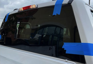 Replacement of a rear windshield on a van, taped for precise installation at WindshieldHUB
