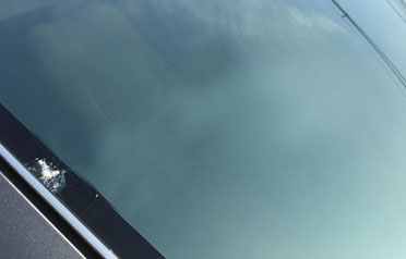 Edge crack near the border of a windshield that can spread if left unrepaired