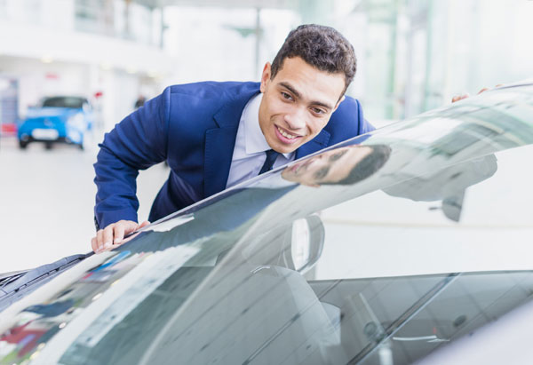 A professional in a business suit inspecting a windshield for damage at WindshieldHUB