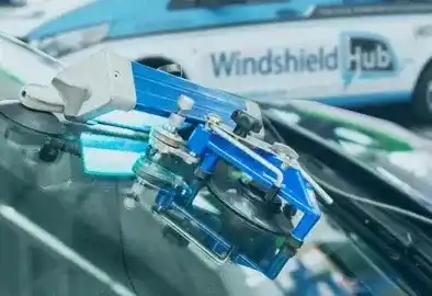 Specialized auto glass repair tool in action on a car's windshield, showcasing WindshieldHUB's high-tech equipment